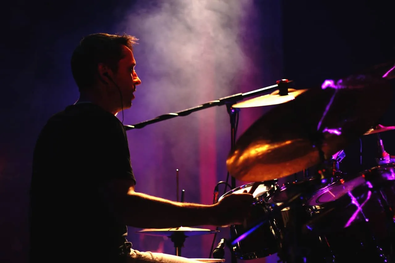 Batteur qui joue avec éclairage de concert.
