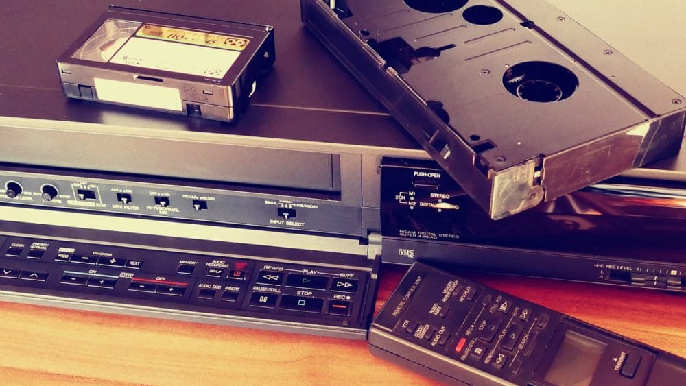 Magnétoscope VHS avec télécommande et cassette sur le dessus.
