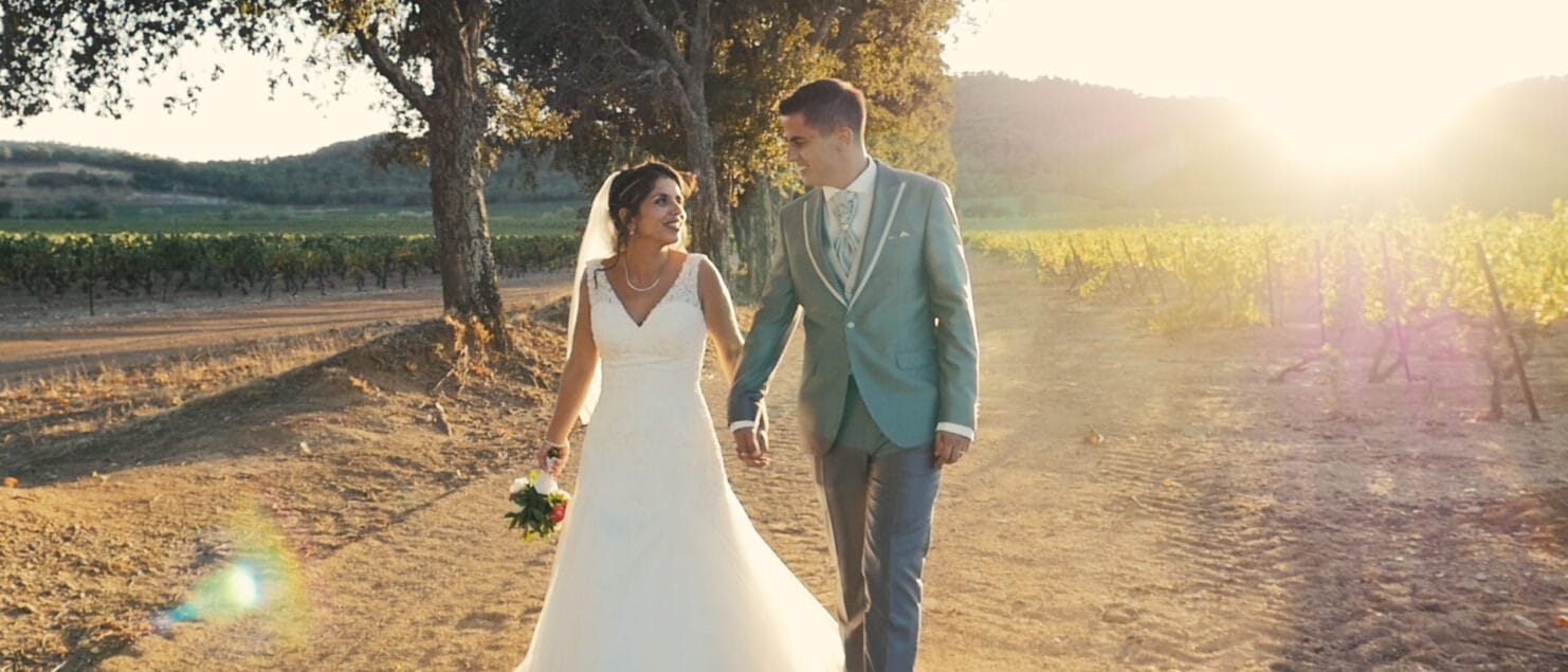 couple de mariés marchant le long des vignes.