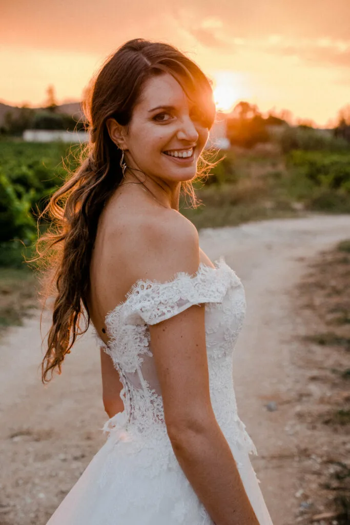 Mariée souriante avec le soleil derrière sa tete