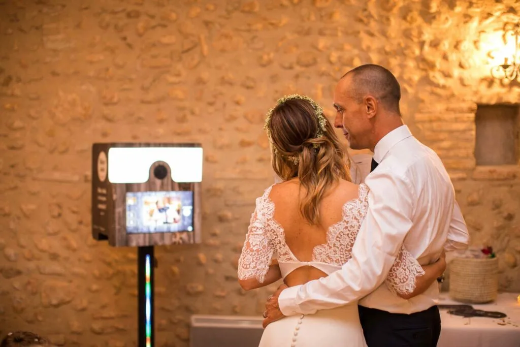 Couple de mariés devant une borne photobooth