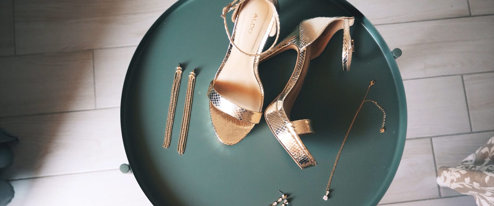 Chaussure de mariée et bijoux sur une petite table verte