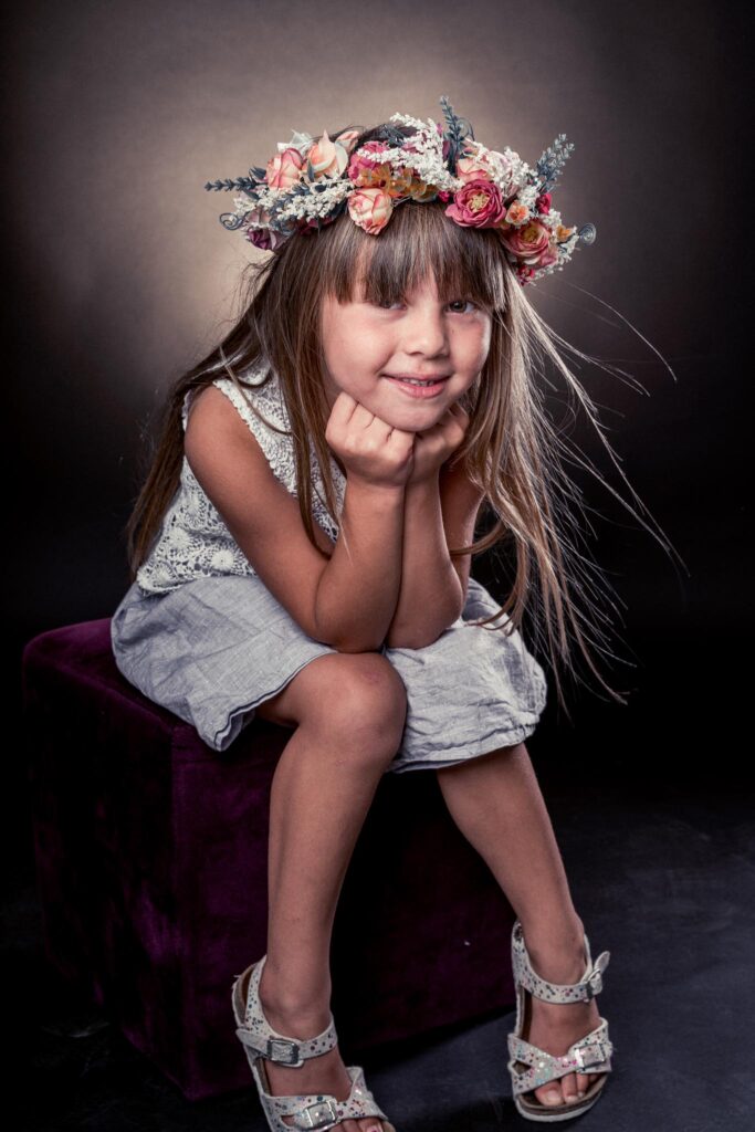 jeune fille assise avec une couronne de fleur sur la tête