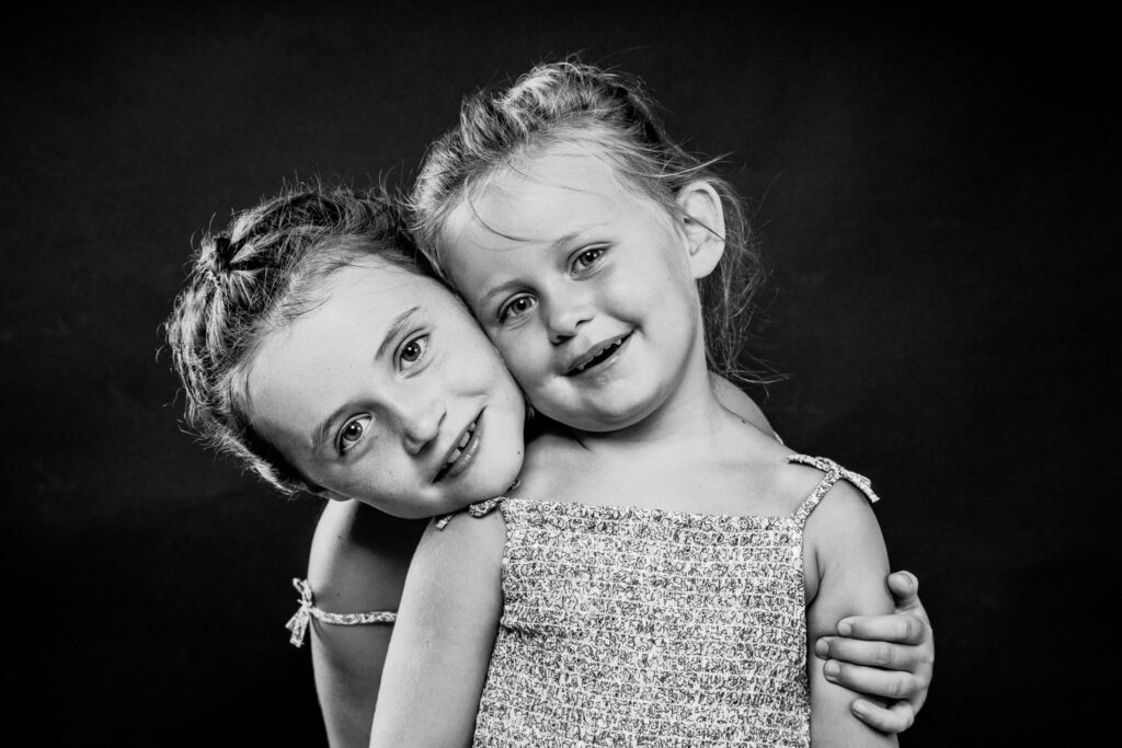 Portrait 2 jeunes filles en noir et blanc en studio sur fond noir