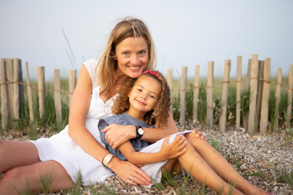 Femme et sa fille assise à la plage avec le sourire