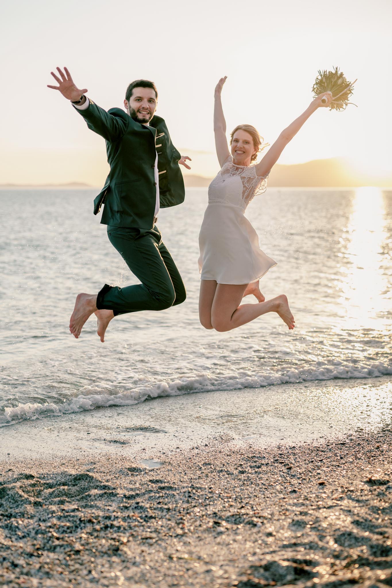 les mariés sautant sur la plage en même temps