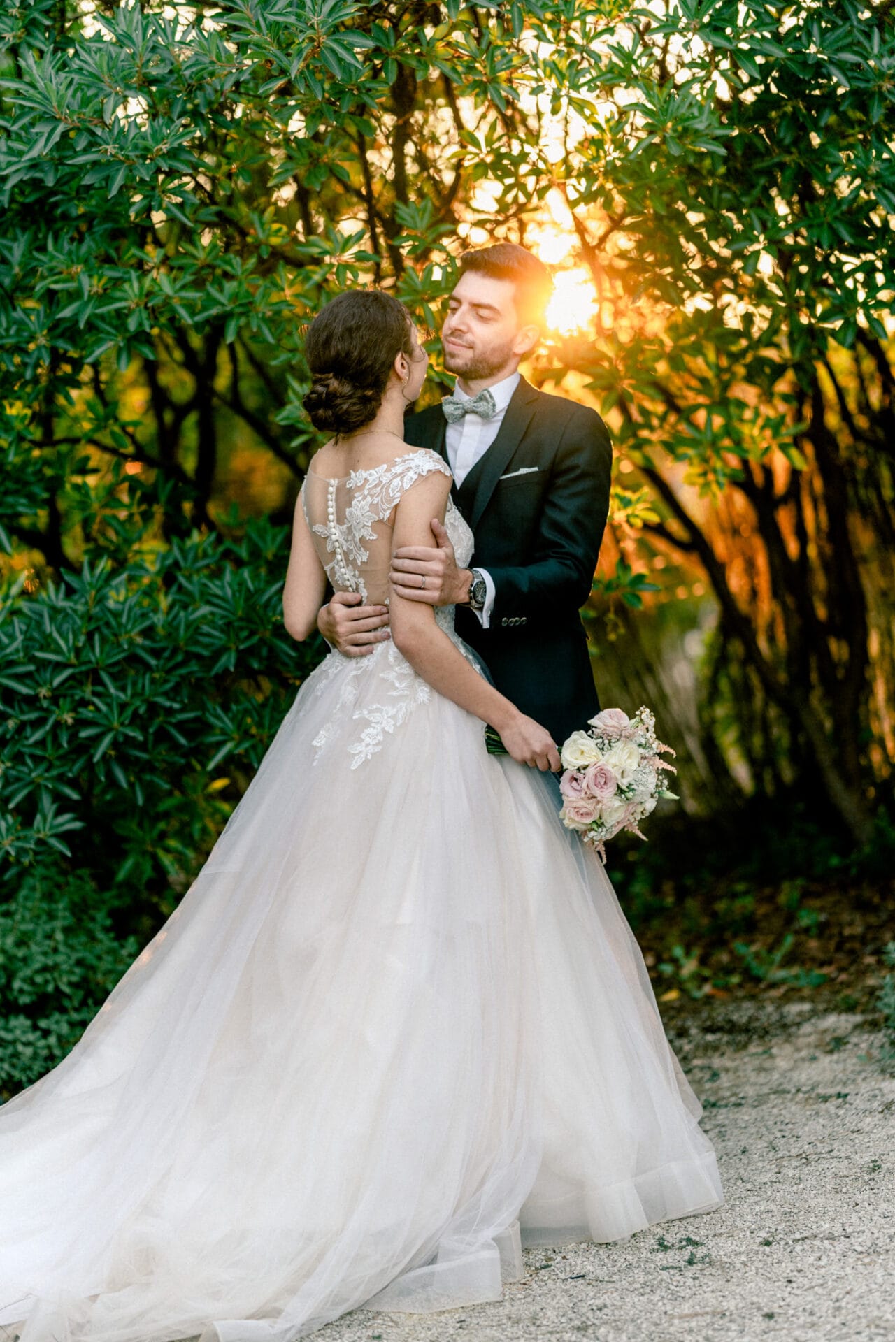 un couple de mariés avec un coucher de soleil derrière